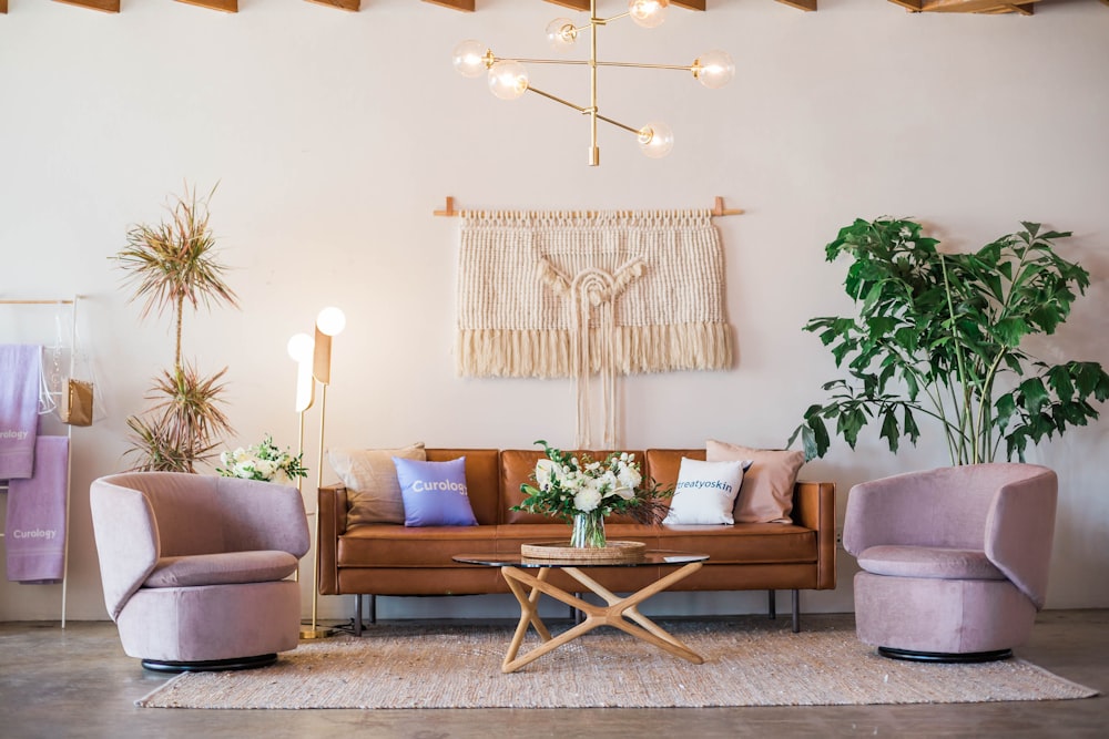 Stilrent stueinteriør med sofa, lenestoler og grønne planter